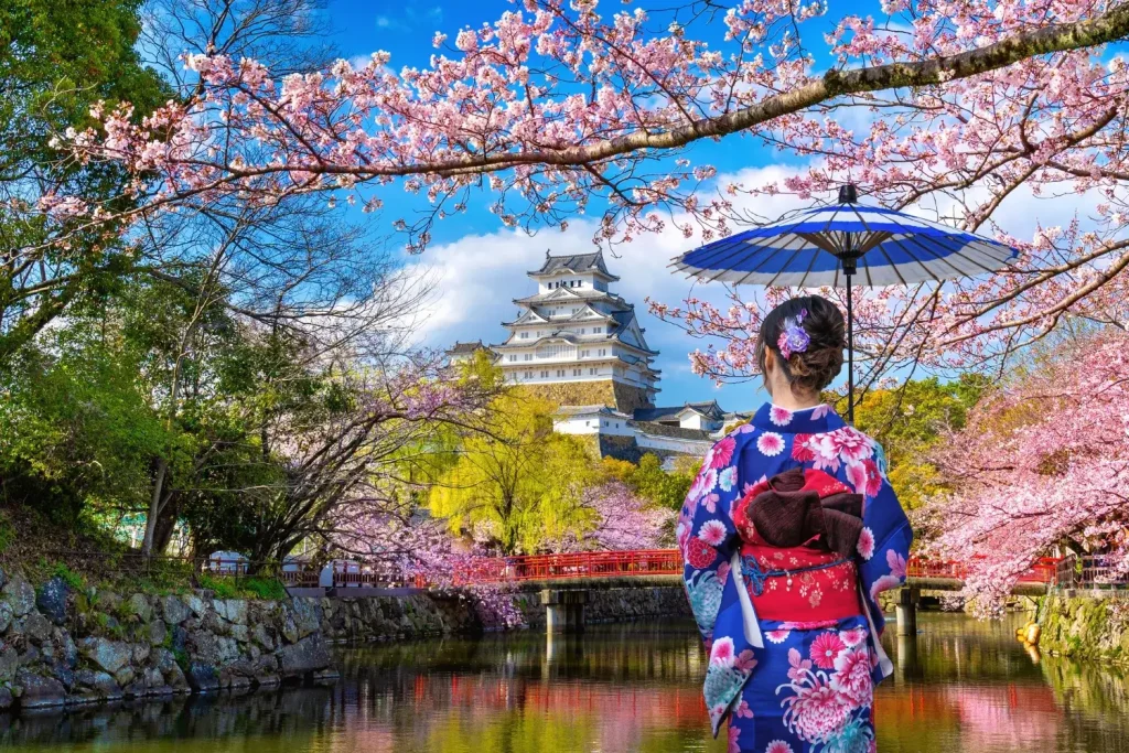 Femme asiatique en kimono devant le château de Himeji, Japon.