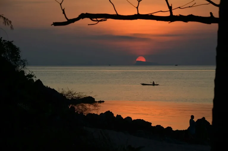 Silhouette d'une personne naviguant sur la mer au coucher du soleil