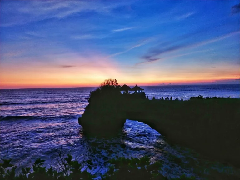 Silhouette de formation rocheuse sur la mer au coucher du soleil