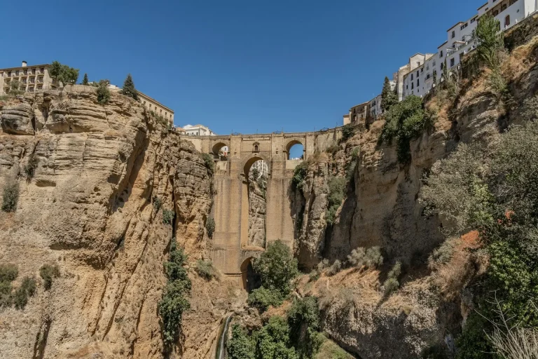 Un pont très haut sur un canyon à côté d'une falaise