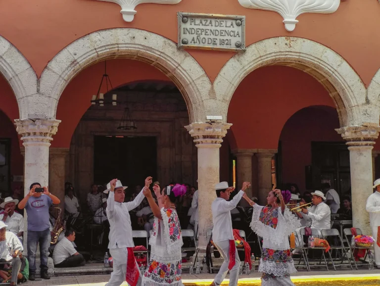 Personnes près d'un bâtiment en béton rouge pendant la journée au Mexique
