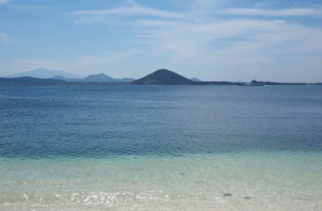 Plage avec vue sur les montagnes et eau claire bleue, Jeju, Corée du Sud