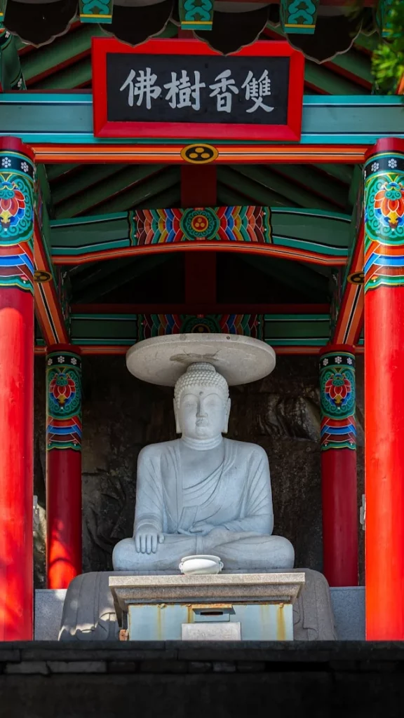 Statue d'une personne assise sur une chaise devant un mur coloré, Busan, Corée du Sud