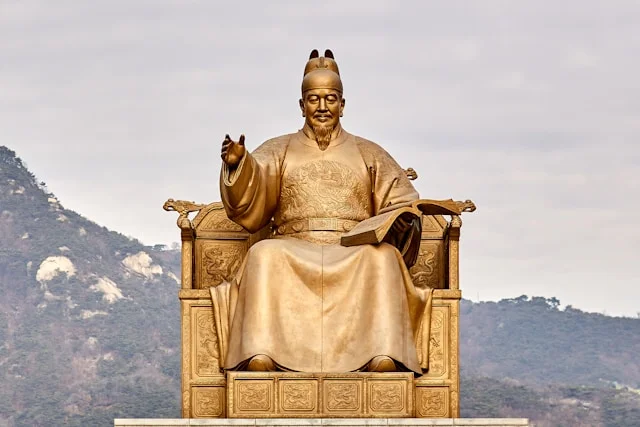 Statue en or d'un homme assis sur un trône