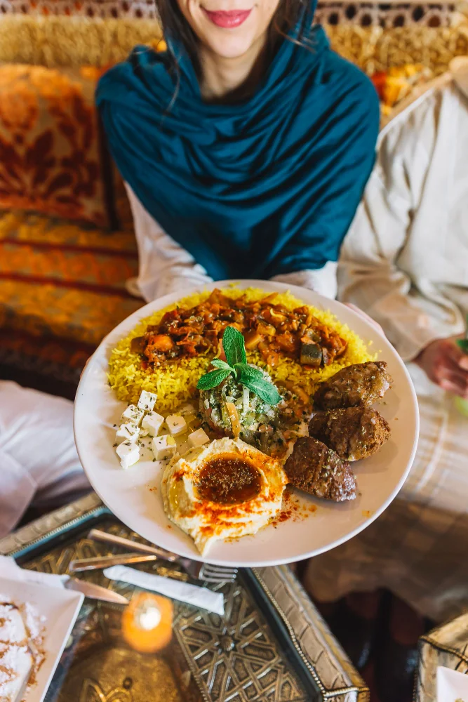 Femme avec un plat arabe dans un restaurant