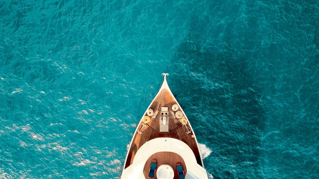 Vue aérienne d'un yacht sur l'océan turquoise.