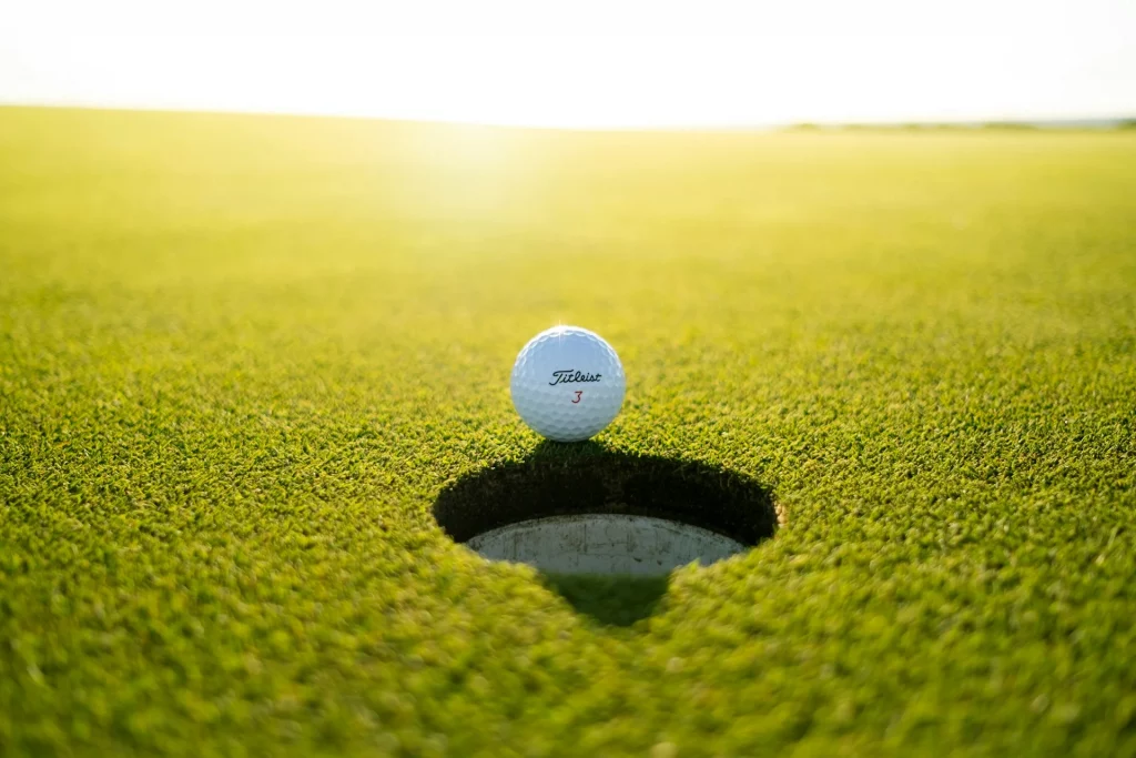 Balle de golf près du trou sur le green.