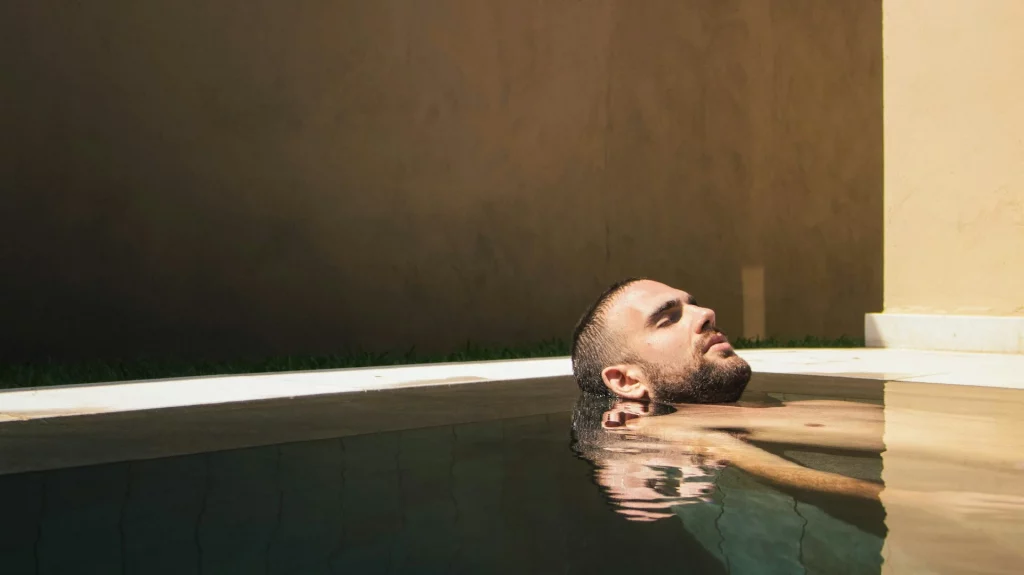 Homme se relaxant dans une piscine privée.