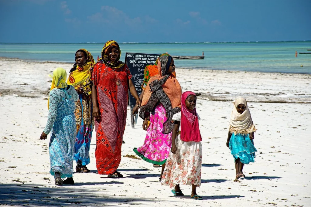 Femmes en tenue traditionnelle sur une plage de Zanzibar.