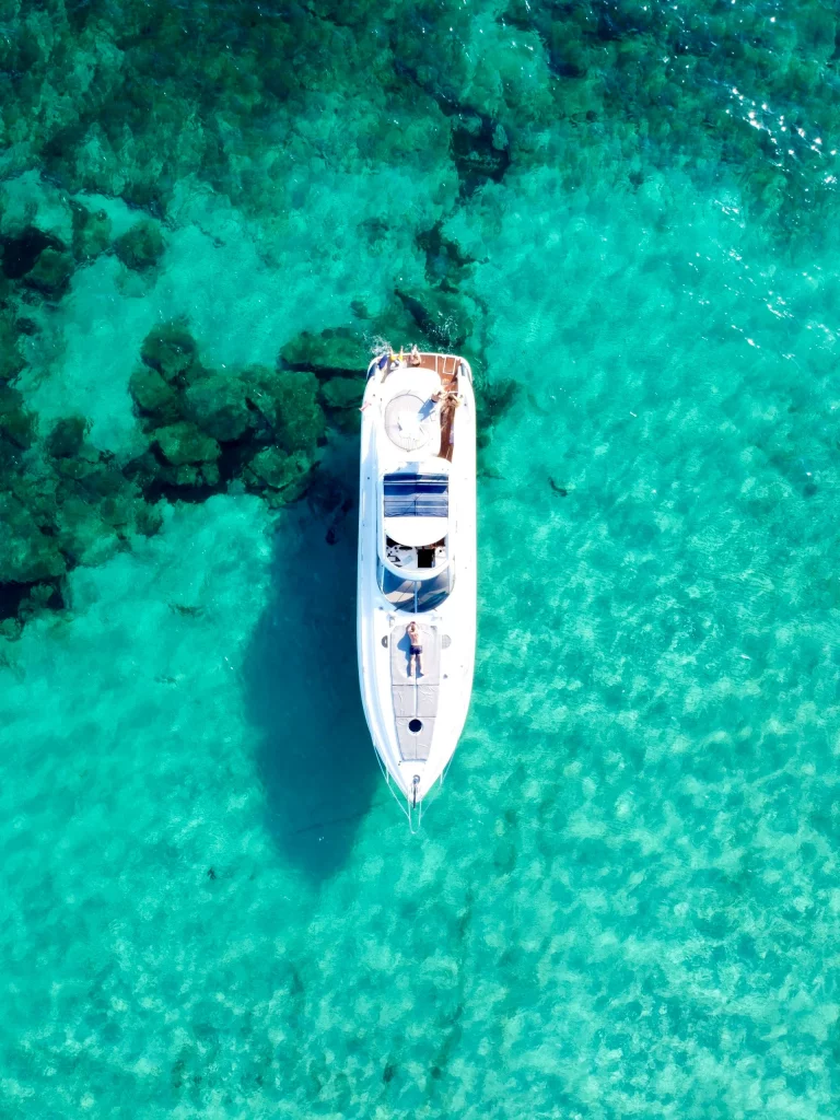 Vue aérienne d’un yacht flottant dans des eaux cristallines