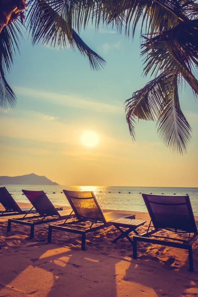 Scène de plage au coucher du soleil avec chaises longues