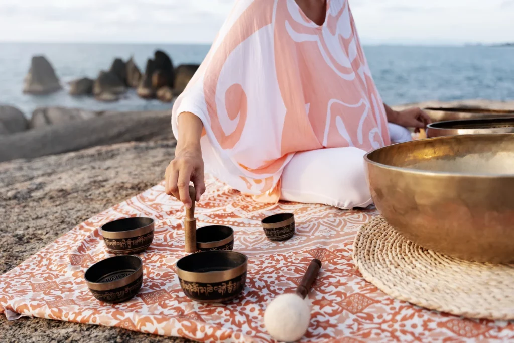 Méditation avec un bol chantant tibétain au bord de la mer