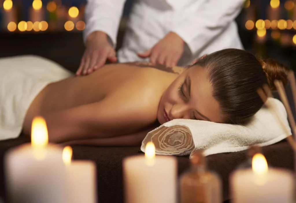 Femme recevant un massage relaxant dans un spa, enveloppée dans un environnement apaisant et élégant